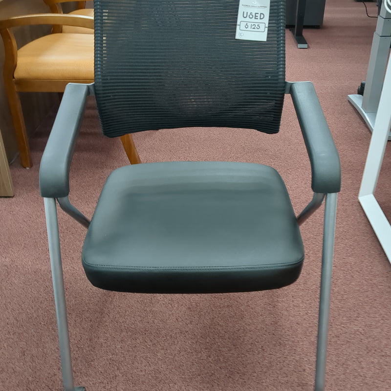 USED Guest chair with leather seat, fixes arms, and casters