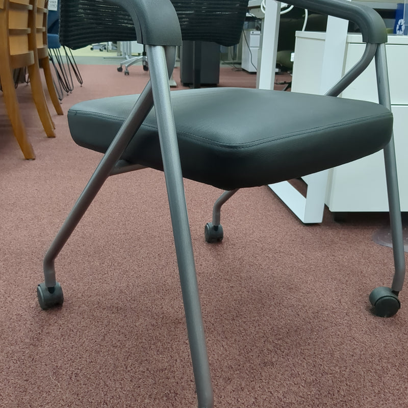 USED Guest chair with leather seat, fixes arms, and casters
