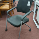 USED Guest chair with leather seat, fixes arms, and casters